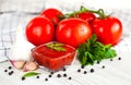 Red sauce or ketchup in a glass bowl and ingredients for his cooking, tomatoes, garlic, basil, parsley, black pepper and spices on Royalty Free Stock Photo