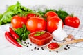 Red sauce or ketchup in a glass bowl and ingredients for his cooking, tomatoes, garlic, basil, parsley, red hot pepper and spices Royalty Free Stock Photo
