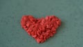Red confetti laid in heart figure blown away