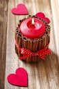 Red scented candle decorated with cinnamon sticks. Royalty Free Stock Photo