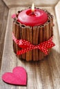 Red scented candle decorated with cinnamon sticks. Royalty Free Stock Photo