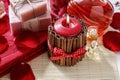 Red scented candle decorated with cinnamon sticks. Rose petals a Royalty Free Stock Photo