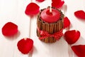 Red scented candle decorated with cinnamon sticks. Rose petals a Royalty Free Stock Photo