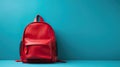 Red school backpack against blue background, copy space Royalty Free Stock Photo