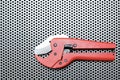 Red scissors for cutting plastic pipe on metal surface Royalty Free Stock Photo
