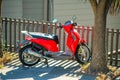 Red scooter or motor bike with kick stand and suburban neighborhood background in late afternoon sun Royalty Free Stock Photo