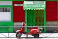 Madrid, Spain - 18 July 2018: Red scooter near green and red wall, city center of Madrid.