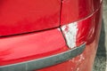 Red scratched car with damaged paint in crash accident or parking lot and dented damage of bumper metal body from collision Royalty Free Stock Photo