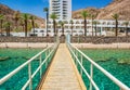 Red sea coral beach local tropic scenery landscape near Israeli city Eilat with aquamarine transparent water and wooden pier on Royalty Free Stock Photo