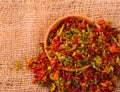 Red seasoning with pepper in a wooden cup and sacking. Royalty Free Stock Photo