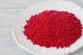 Red seed beads on a white plate. Royalty Free Stock Photo
