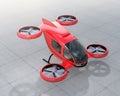 Red self-driving passenger drone landing on the ground