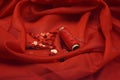 Red sequins, spool of red thread and needle on rippled red silk background. Royalty Free Stock Photo