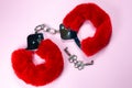 Red sexy fluffy handcuffs with keys on a pink background Royalty Free Stock Photo