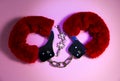 Red sexy fluffy handcuffs with keys on a pink background Royalty Free Stock Photo