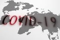 Red shadows spelling covid-19 over world map. Royalty Free Stock Photo