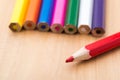 Red sharp pencil stands out from the crowd of colored, non-sharp pencils