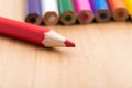 Red sharp pencil stands out from the crowd of colored, non-sharp pencils