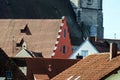 A red shield between the roofs of the original houses of an ancient town