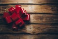 Red shiny bow on rustic background close up. Christmas bow on wooden boards with copy space. Holiday greeting card Royalty Free Stock Photo