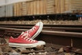 Red shoes leaning on the train tracks.