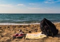 Red shoes sneakers towel and backpack left on the beach by the sea. run to the sea. escape for a quick dive Royalty Free Stock Photo