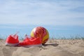 Red shoes and ball on a beach background Royalty Free Stock Photo