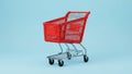 Red Shopping Cart on a Solid Blue Background Royalty Free Stock Photo