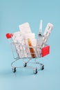 Red shopping trolley cart with medicinal pills and tablets closeup