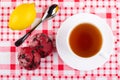 Red cookies, lemon, teaspoon, cup of tea on saucer on napkin. Top view Royalty Free Stock Photo