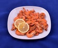 Red shrimps cooked with butter, garlic and lemon on white plate