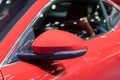 Red side view mirror with red sport modern car. Royalty Free Stock Photo