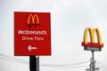 The red sign of McDonald drive thru at daylight and out focus dicut style of McDonald`s logo.