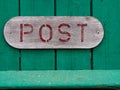 Red sign of an old vintage mail letter box post on green wood Royalty Free Stock Photo