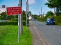 A red sign warns motorists of a new 30mph speed limit in force in the rural village of Halsall in Lancashire, UK