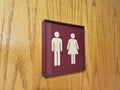 Red sign with white male and female symbols indicating unisex bathroom