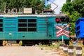 Red signal of semaphore and stop sign in front of railroad crossing with train passing Royalty Free Stock Photo