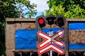 Red signal of semaphore and stop sign in front of railroad crossing with train passing Royalty Free Stock Photo