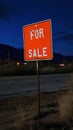 Red signpost with the words For sale against the night landscape backdrop. For sale button concept. Generative AI