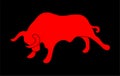 Red silhouette of a raging bull over black background