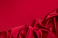 Red silk satin background. Copy space for text or product. Wavy soft folds on shiny fabric.