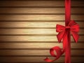 Red Silky Bow with Ribbon over Wooden Background