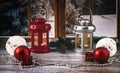 Red and silver lanterns with candles on the background of the window. Christmas balls, necklace, toys and fir branches as decor. Royalty Free Stock Photo