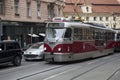 Red and silver vintage tram driving on a street in the city