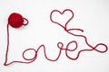 Red skein of thread against white background. Red ball of wool with red thread writes a word LOVE isolated on white. Heart and Royalty Free Stock Photo