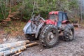 The red skidder in the forest. The timber skidding machine. Large rubber wheels with chains Royalty Free Stock Photo