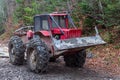 The red skidder in the forest. The timber skidding machine. Large rubber wheels with chains Royalty Free Stock Photo