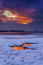 Red sky sunset over snowy Poole beach Royalty Free Stock Photo