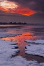 Red sky sunset over snowy Poole beach Royalty Free Stock Photo