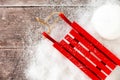 Red Sledge and Snowball in Snow and on Brown Wood Royalty Free Stock Photo